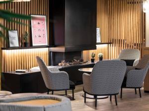 ein Esszimmer mit Stühlen und einem Kamin in der Unterkunft Mercure Luxembourg Off Kirchberg in Luxemburg (Stadt)