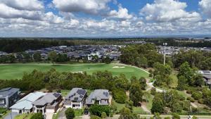 an overhead view of a golf course with houses at Golf Course Frontage House in Schofields