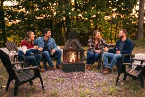 Eine Gruppe von Menschen sitzt um ein Feuer in der Unterkunft Elios Private Spa & BBQ, Lake & Golf in Brownsburg