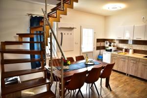 a kitchen and dining room with a wooden table and stairs at Gyömbér Tanya in Ásotthalom