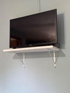 a flat screen tv sitting on a white shelf at Suítes em Bacaxá Saquarema in Saquarema