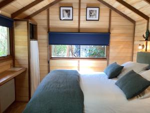 a bedroom with a large bed in a wooden cabin at La Crampotte de Bidart, proche Océan in Bidart