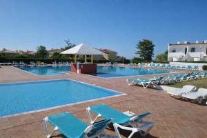 a large swimming pool with lounge chairs and a swimming pool at Serenity Villa in Porches