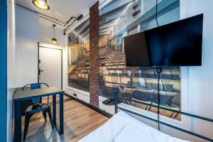 a room with a desk and a tv on a wall at Vola Hostel in Warsaw