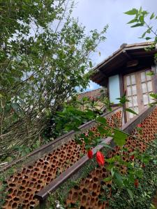 a wall with red flowers on the side of a house at Chalé Vale do Amor in Araras Petropolis