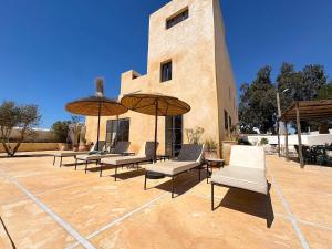 a group of chairs and umbrellas in front of a building at Palais Zoa in Essaouira +56 photos