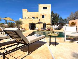 a patio with a chair and a table next to a pool at Palais Zoa in Essaouira