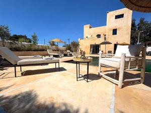 a patio with chairs and a table and a building at Palais Zoa in Essaouira