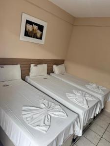 two beds sitting next to each other in a room at Pousada Jasmine in João Pessoa +77 photos