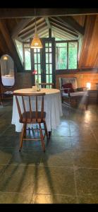 a dining room with a table and a chair at Chalé Vale do Amor in Araras Petropolis