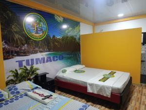 two beds in a room with a mural on the wall at Hotel Pablo's in Tumaco