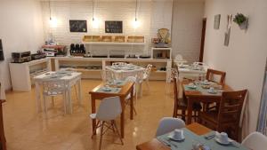 a dining room with tables and chairs and a kitchen at Hotel Amadora Palace in Amadora