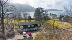 a house with two cars parked in front of it at Faodail in Onich