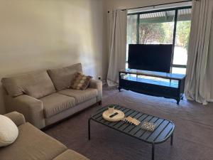 a living room with a couch and a tv at Manor on McIntyre in Horsham +8 photos