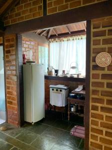a kitchen with a refrigerator and a stove at Chalé Vale do Amor in Araras Petropolis +1 photo