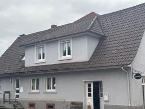 a gray house with white windows and a roof at Heimelige Wohnung Bei der Stoffschmiede in Schutterwald