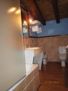 a bathroom with a tub and a sink and a toilet at Hostal Rural Jarpar in Grajera