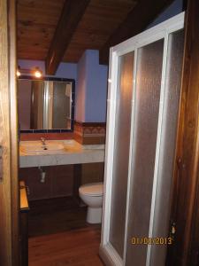 a bathroom with a toilet and a sink at Hostal Rural Jarpar in Grajera
