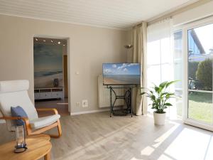 a living room with a chair and a table with a television at Häuschen im Grünen in Bansin