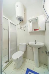 Baño blanco con aseo y lavamanos en Villa Barcelona, en Sutomore