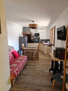 a living room with a table and a kitchen at le balcon du Canigo' in Escaro