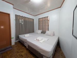 a bedroom with a bed with two towels on it at Rubilla's Homestay and Motor Rental in Mambajao
