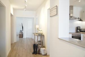 a kitchen with white walls and a wooden floor at Ferienwohnung Zweites Zuhause in Büsum
