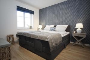 a bedroom with a large bed and a wall at Ferienwohnung Zweites Zuhause in Büsum +5 photos