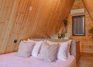 a bed in a room with wooden walls and a window at Reserve Resort Lagodekhi in Lagodekhi +15 photos