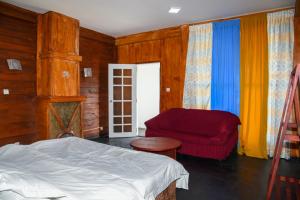 a bedroom with a bed and a red chair at Shiny cot resort in Nuwara Eliya
