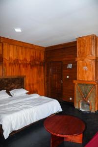 a bedroom with a bed and a wooden wall at Shiny cot resort in Nuwara Eliya