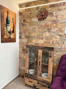 a stone wall with a fireplace with a purple couch at Tokaj Lamour in Tokaj +30 photos