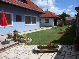 a backyard of a house with a yard with red flowers at Apartment in Balatonbereny/Balaton 18043 in Balatonberény