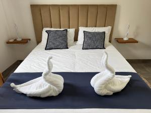 two swans sitting on top of a bed at Serenità - Seaview Penthouse in Marsaskala