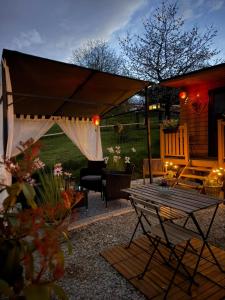 a patio with a tent and a table and chairs at Tiny House Beija-Flor in Challex