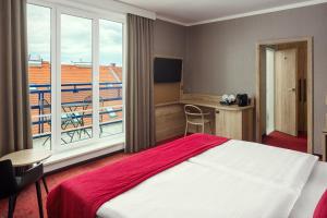a hotel room with a large bed and a balcony at Astoria Hotel in Prague