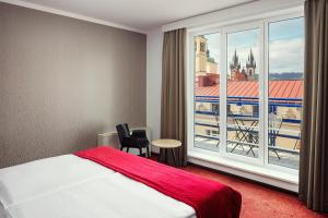 a hotel room with a bed and a large window at Astoria Hotel in Prague