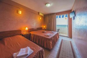 a hotel room with two beds and a window at Villa Barcelona in Sutomore