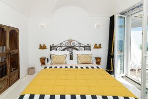 a bedroom with a large bed with a yellow blanket at Villa Pietra Santa in Positano