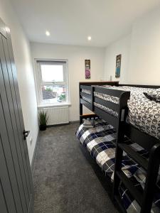 a bedroom with two bunk beds and a window at Spacious 4 Bed Retreat, 2 Bath, Sleeps 8 plus 2, Beach, Bars, Dinning, Shops, Golf, for Groups, Contractors or Families in Bournemouth