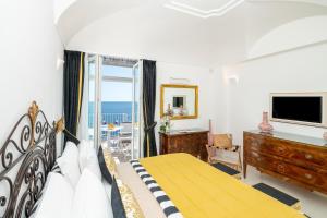 a bedroom with a bed and a balcony with the ocean at Villa Pietra Santa in Positano