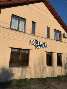 a building with a sign on the side of it at Eclipse grill and pizza in Corunca