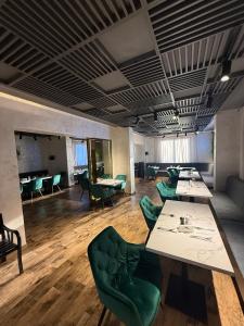 a conference room with tables and green chairs at Eclipse grill and pizza in Corunca