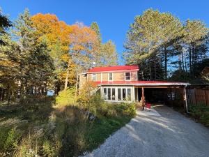 a house with a red roof in the woods at Gîte du Lac-à-la-Loutre - B&B in Huberdeau +46 photos
