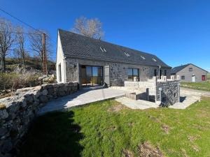 a stone house with a stone wall at Le Ché d'Aubrac in Nasbinals