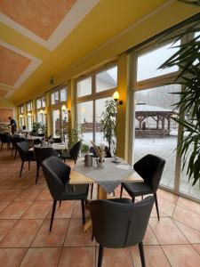 a restaurant with tables and chairs and windows at Alte Schleiferei in Breitenbrunn