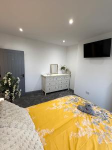 a bedroom with a yellow blanket on a bed at Spacious 4 Bed Retreat, 2 Bath, Sleeps 8 plus 2, Beach, Bars, Dinning, Shops, Golf, for Groups, Contractors or Families in Bournemouth +10 photos