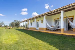 a house with a green lawn in front of it at Monte do Sossego by Portugal Active in Ferreira do Alentejo