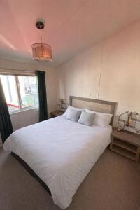 a bedroom with a large white bed with a window at Seaview Holiday Rentals - Pebble Beach in Whitstable +15 photos
