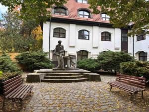 a statue in front of a building with two benches at Tokaj Lamour in Tokaj